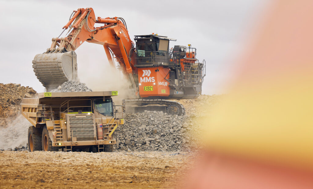 orange-excavator-loading-minerals-onto-haul-truck